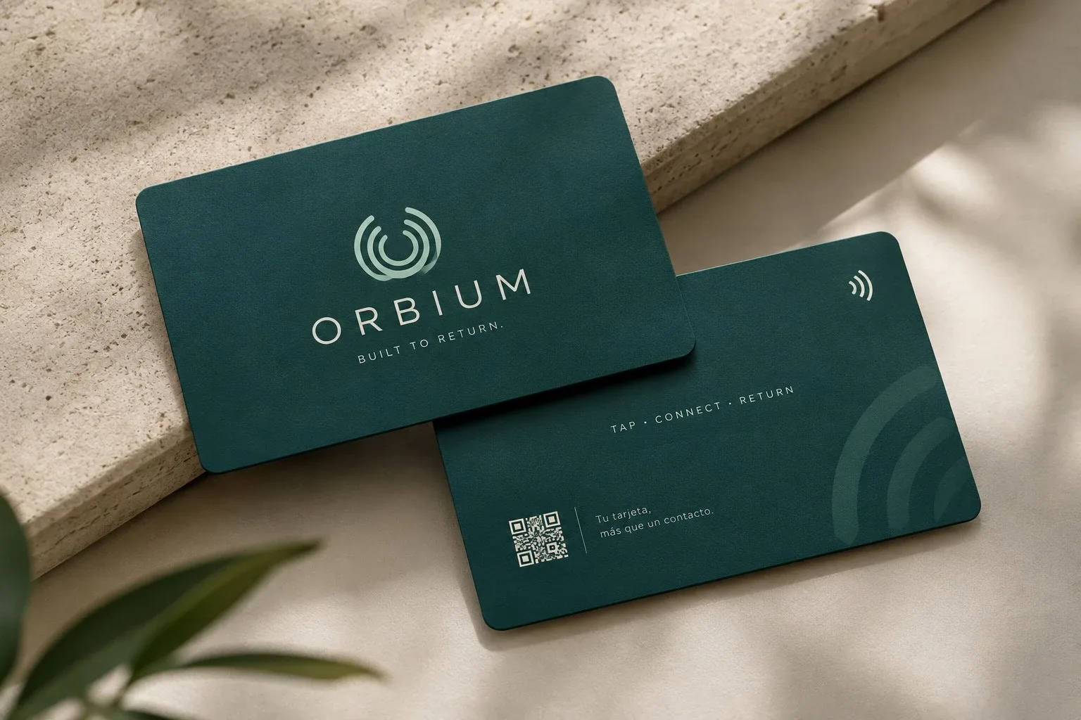 Tarjetas de fidelización Orbium, frente y reverso, en verde pino. El frente lleva el símbolo, la palabra ORBIUM y la frase Built to return; el reverso, un código QR y la leyenda Tap, connect, return.